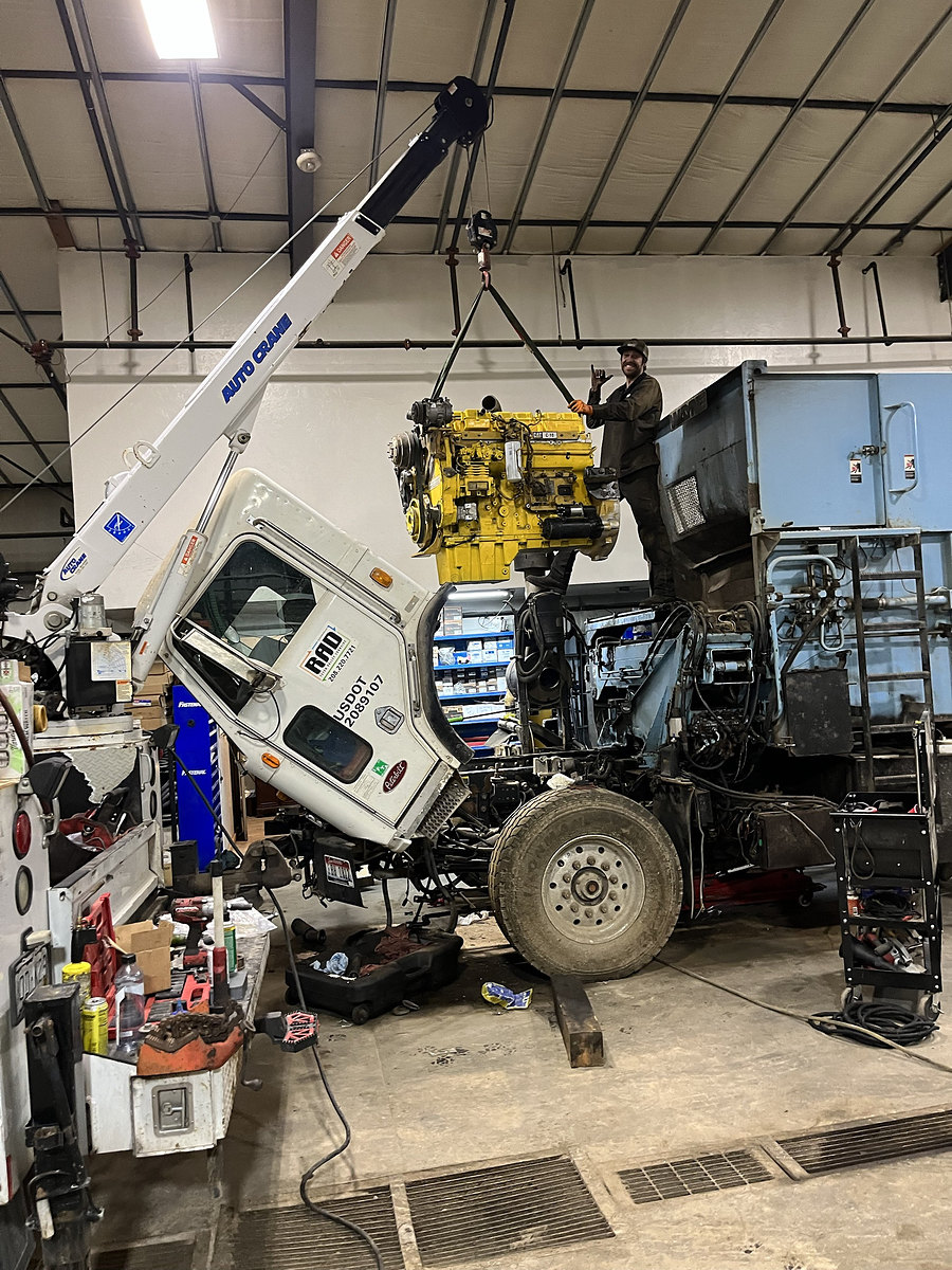 CAT C-10 engine being lifted into a truck with a service crane