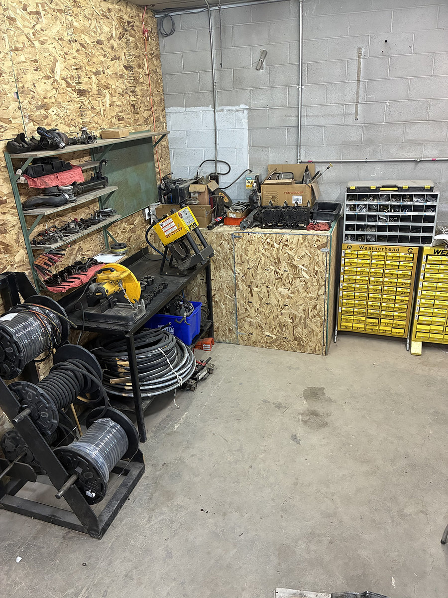 Hydraulic hose crimper, hose reels and fitting bins in the shop