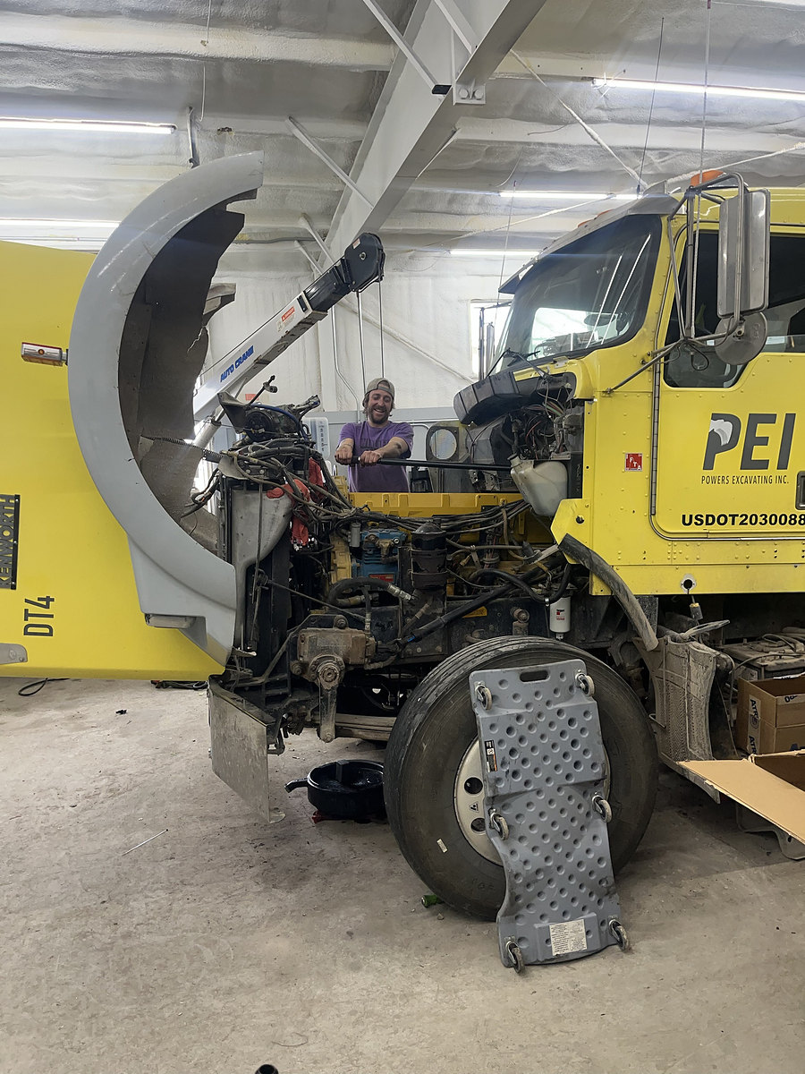 Mechanic working on a Kenworth dump truck engine